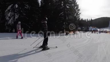 滑雪场滑雪和业余滑雪者的新手女孩滑下滑雪坡